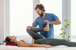 front-view-osteopathic-therapist-checking-female-patient-s-leg-movement