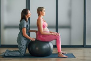 pregnant-woman-pink-clothes-health-center-getting-help-by-doctor_146671-68398